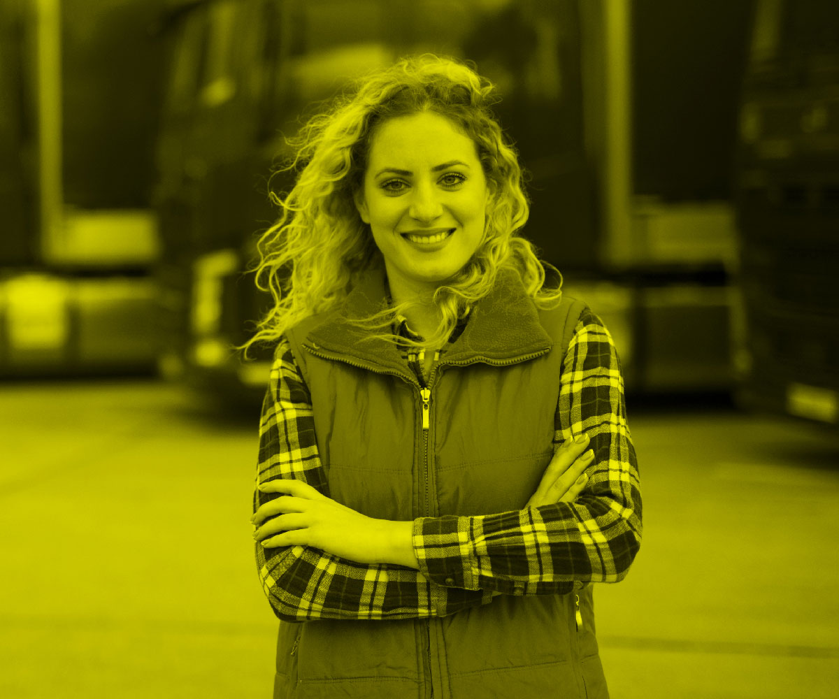 woman smiling in front of fleet of trucks